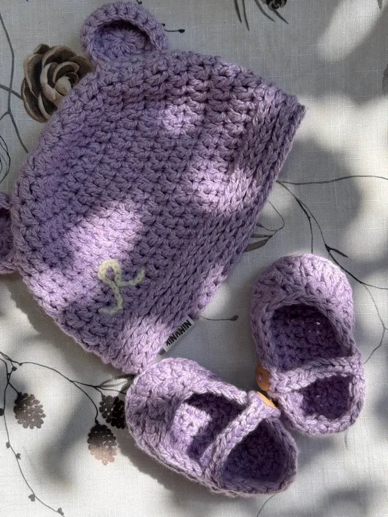 slika prikazuje volneno kapo in copatke za dojenčka Ninunik Butik